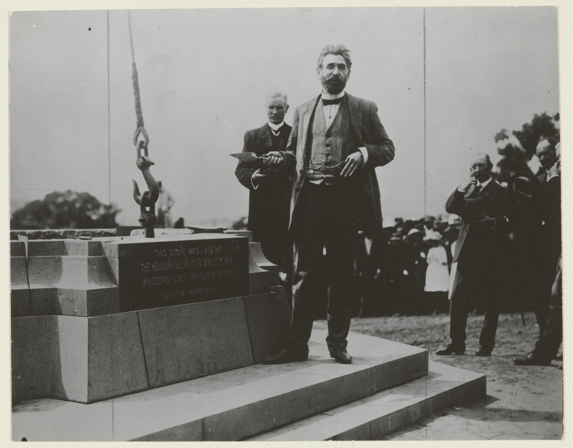 Minister for Home Affairs, King O’Malley, laying the third stone at the ceremony to name Canberra, with Prime Minister Andrew Fisher looking on, 12 March 1913 National Library of Australia VN4699293