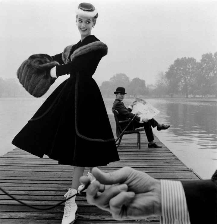 Skater wears a Digby Morton fur trimmed velvet coat, city gentleman Michael Bentley in the background, London. Daily Express, 1955 John French © Victoria and Albert Museum, London
